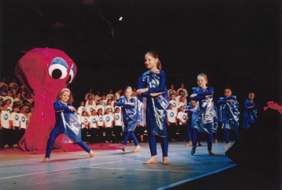 A group of young girls are dancing on a stage