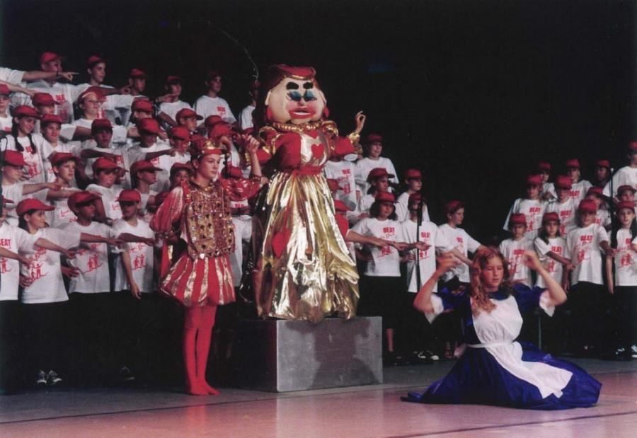 A group of children are watching a performance of alice in wonderland