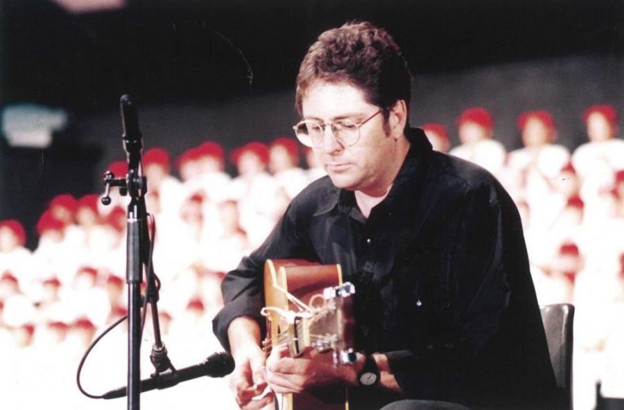 A man playing a guitar in front of a crowd