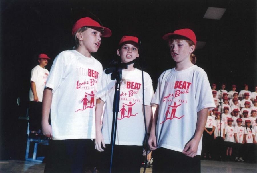 Three students singing in BEAT t Shirts and red caps