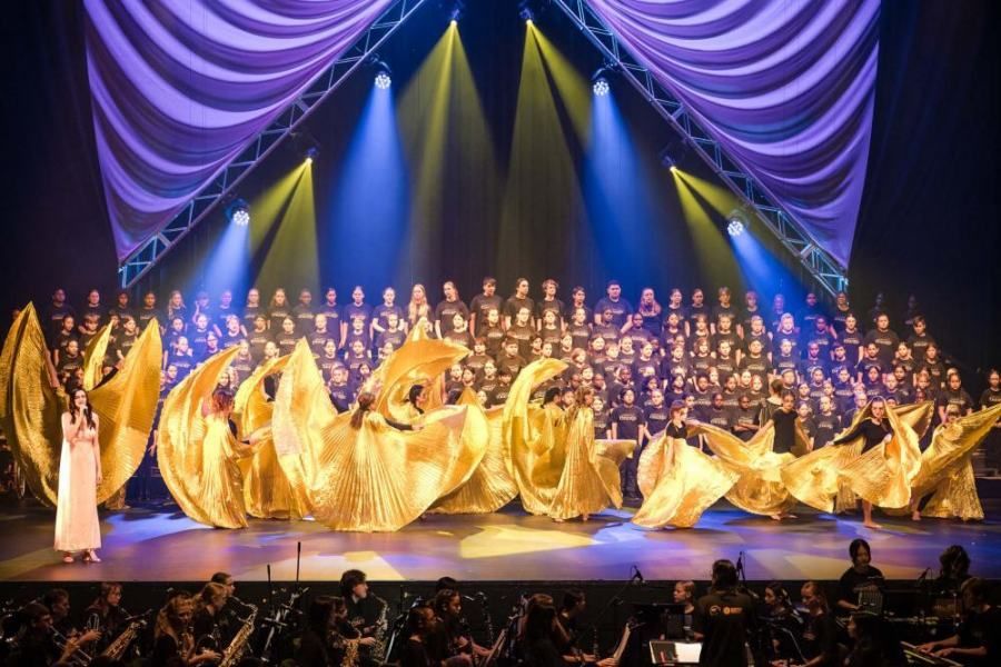 A large group of people are dancing on a stage.