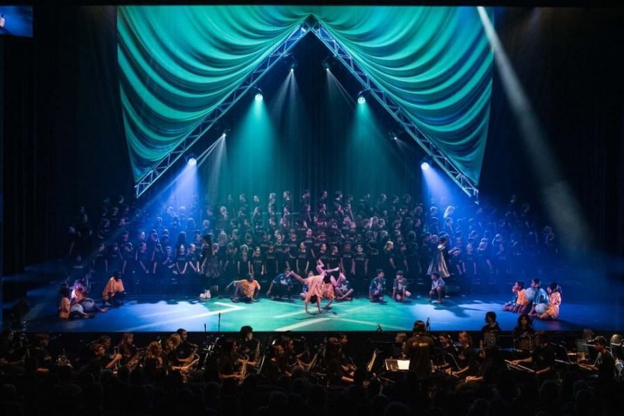 A group of people are performing on a stage in front of a crowd