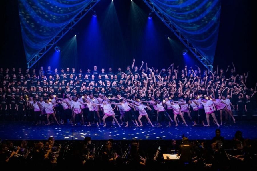 A large group of people are dancing on a stage.