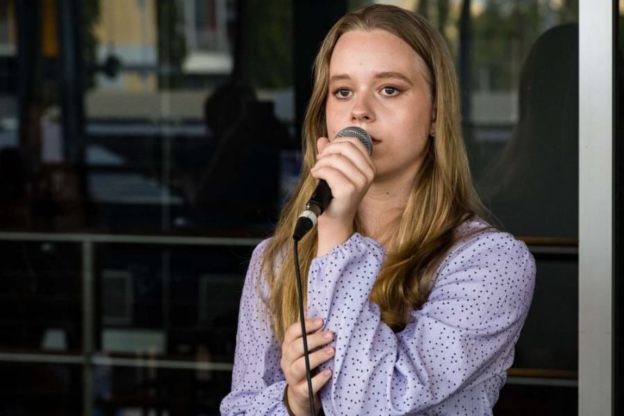 A young woman is singing into a microphone.