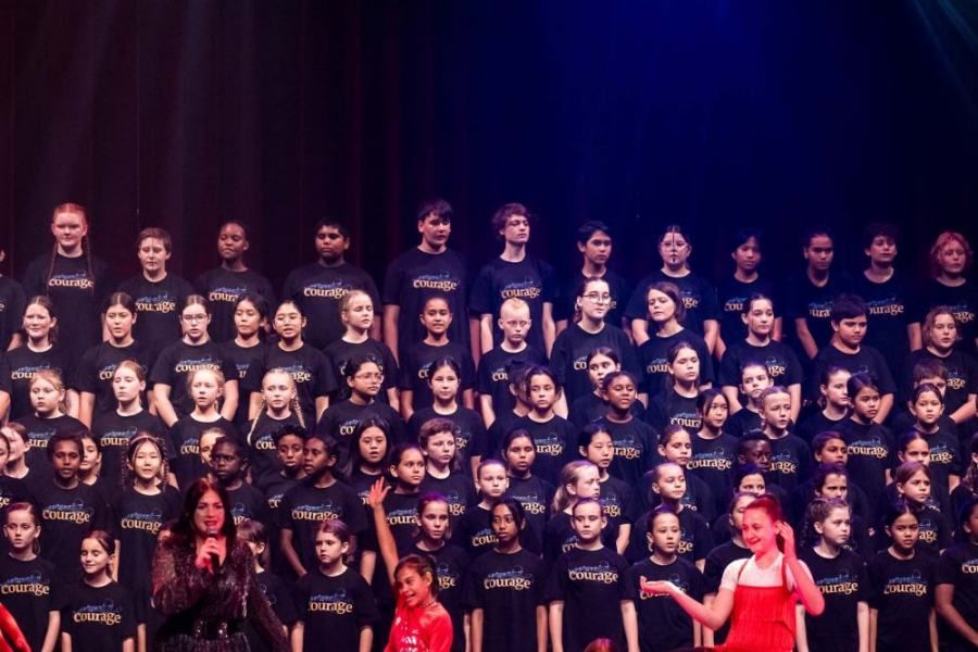 A large group of children are standing on a stage.