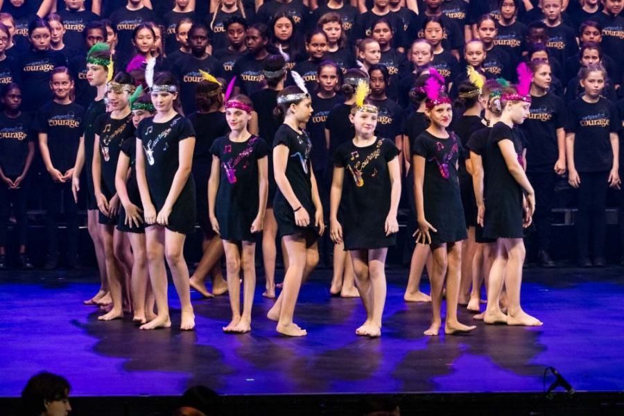 A large group of children are standing on a stage.
