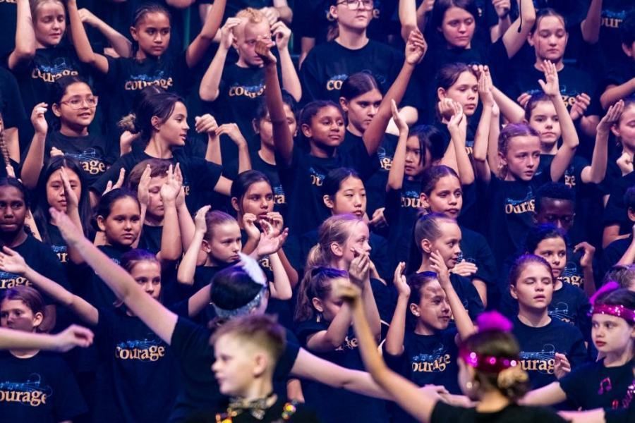 A large group of children wearing black shirts with the word courage on them