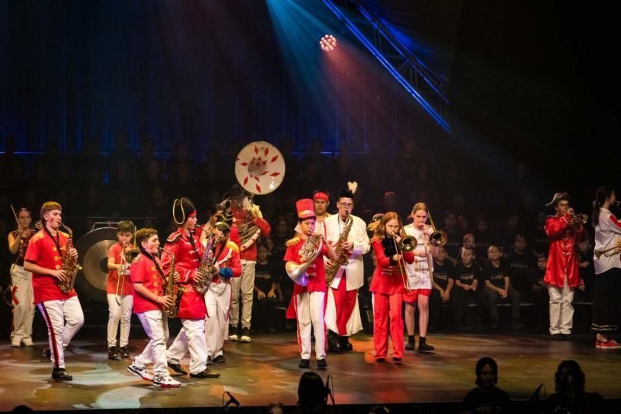 A group of people are standing on a stage playing instruments.