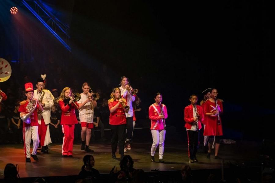 A group of children are playing instruments on a stage.