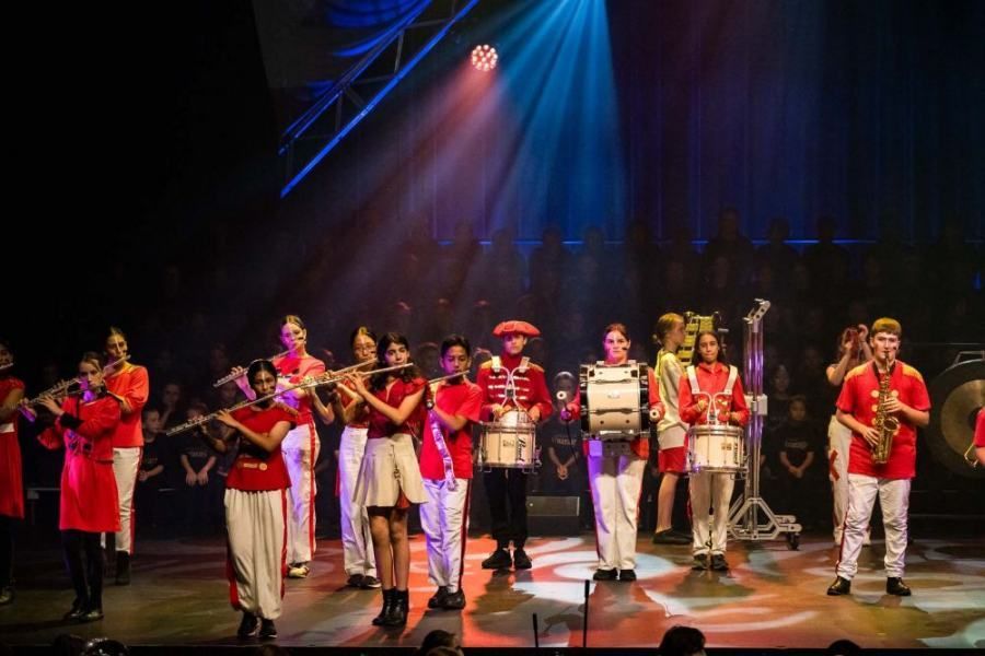 A group of people are standing on a stage playing instruments.