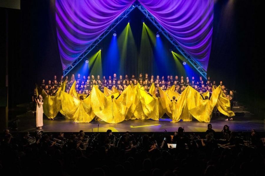 A group of people are dancing on a stage in front of a crowd.
