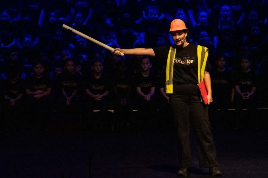 Man dressed up as a construction worker pointing a stick