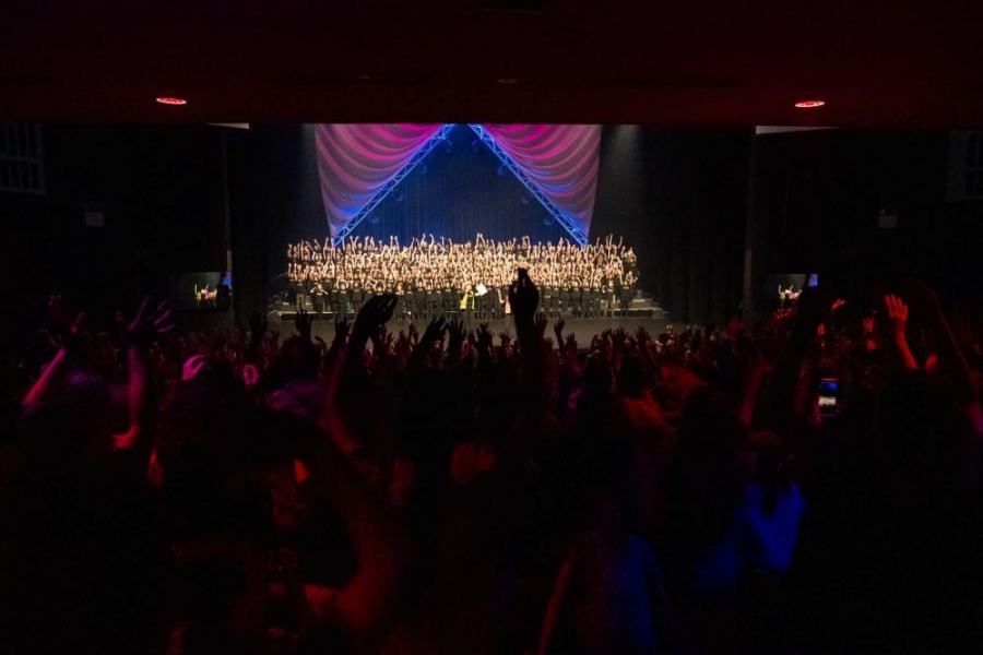 A crowd of people are standing in front of a stage at a concert.