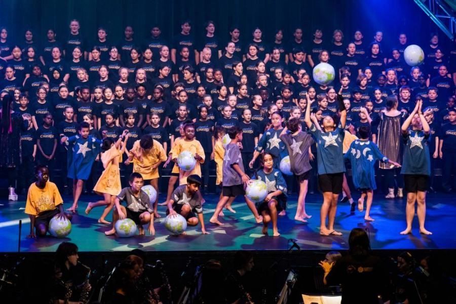 A group of children are playing with soccer balls on a stage.