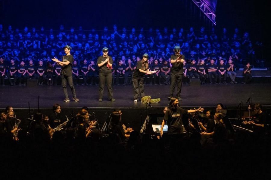A group of people are dancing on a stage in front of a crowd.
