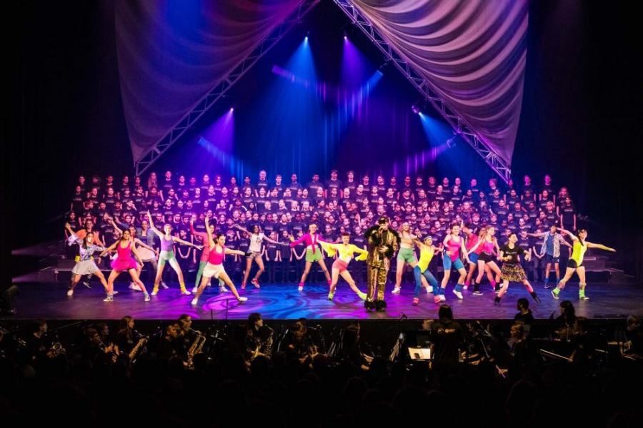 A large group of people are dancing on a stage.