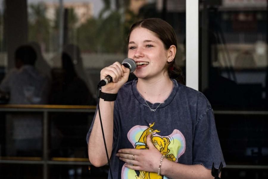 A young woman is singing into a microphone.