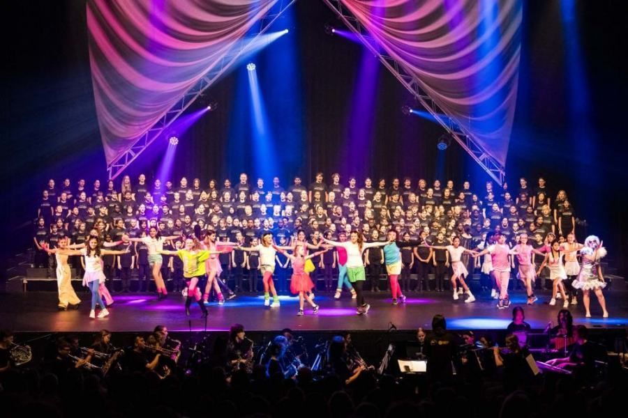 A large group of people are dancing on a stage.