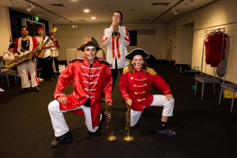 A group of people in pirate costumes are posing for a picture in a room.