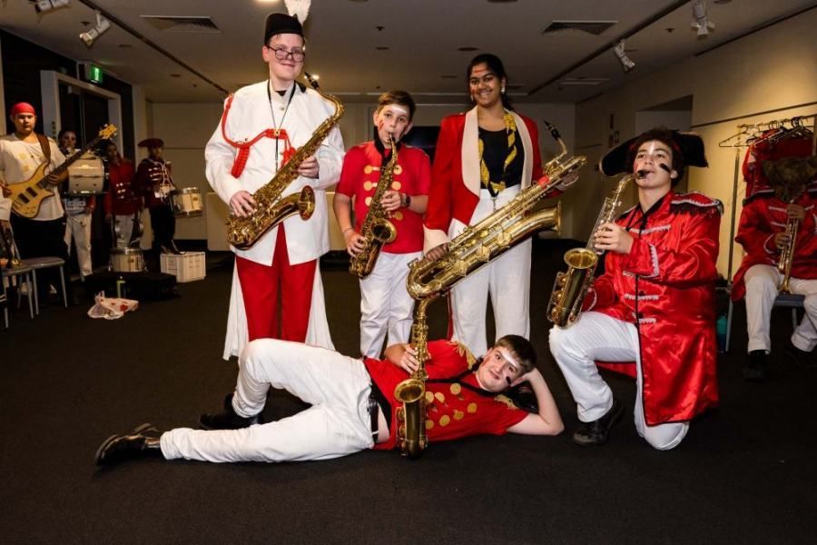 A group of people are playing saxophones in a band.