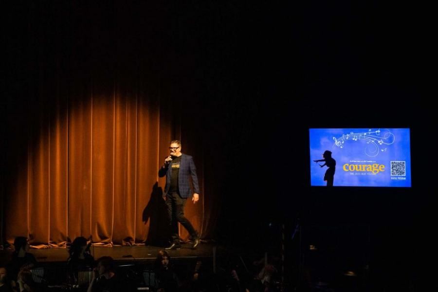 A man is standing on a stage with a microphone in his hand.