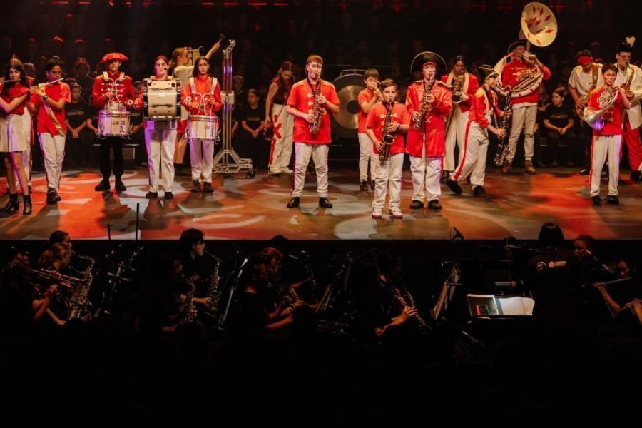 A group of people are standing on a stage playing instruments.