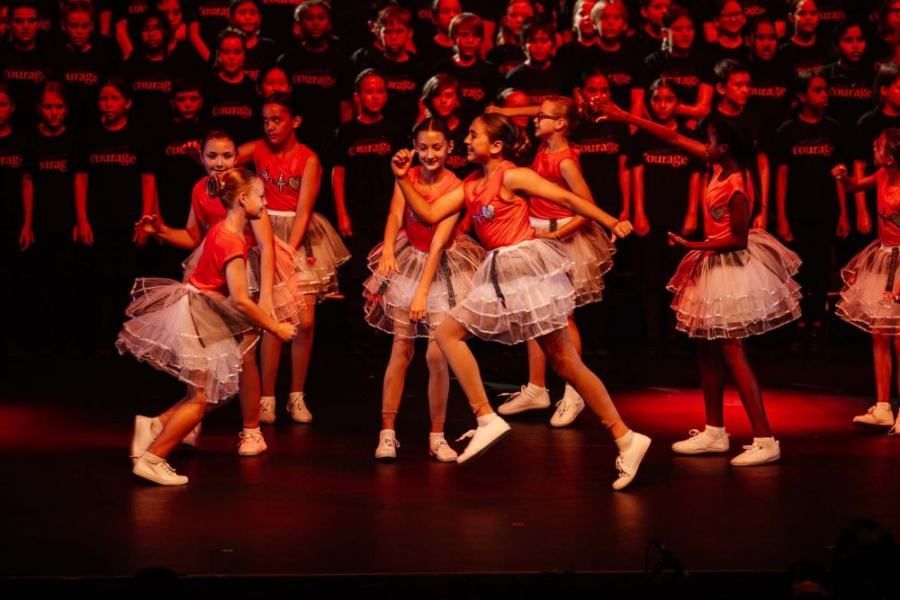 A group of young girls are dancing on a stage.