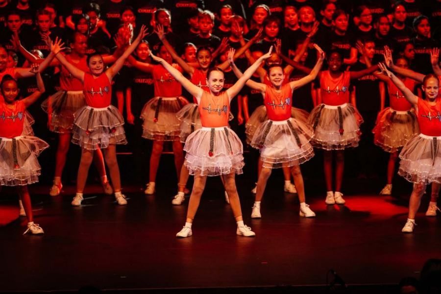 A group of young girls are dancing on a stage.