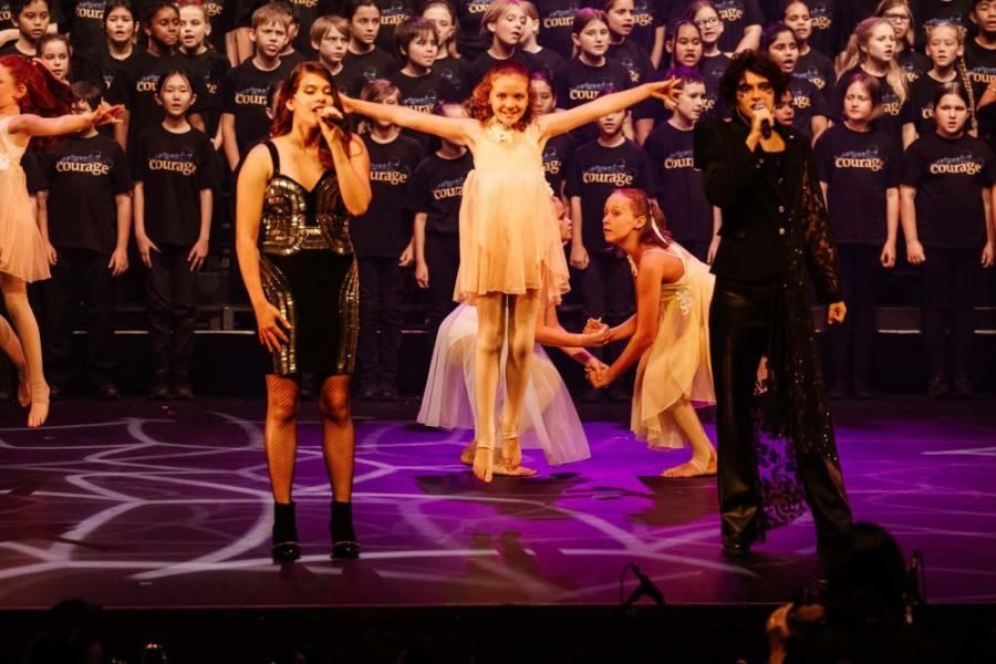 A group of people are standing on a stage in front of a choir.