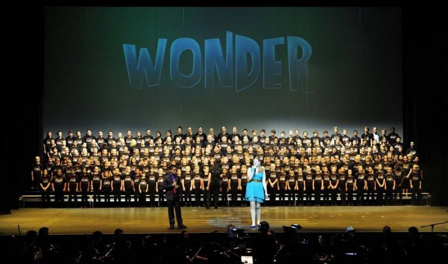 A large group of people on a stage with the word wonder in the background