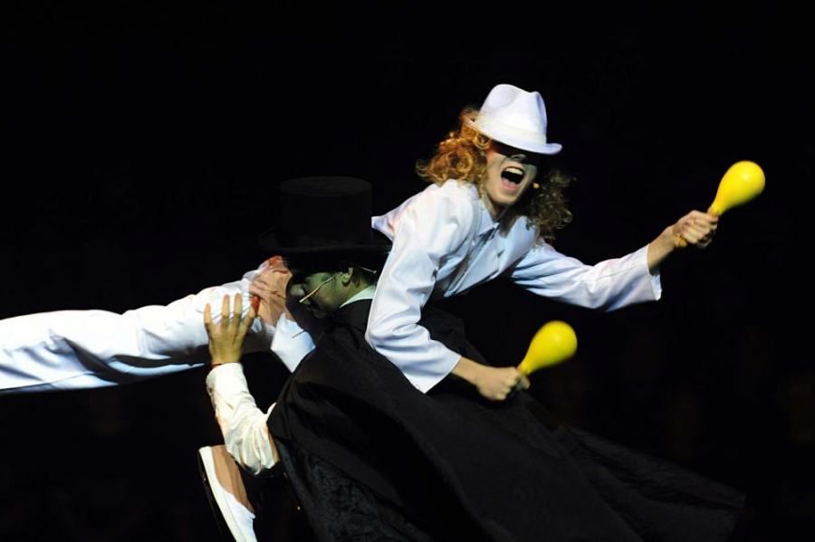 A woman in a white hat is holding a yellow maraca