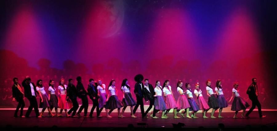 A group of people are dancing on a stage.