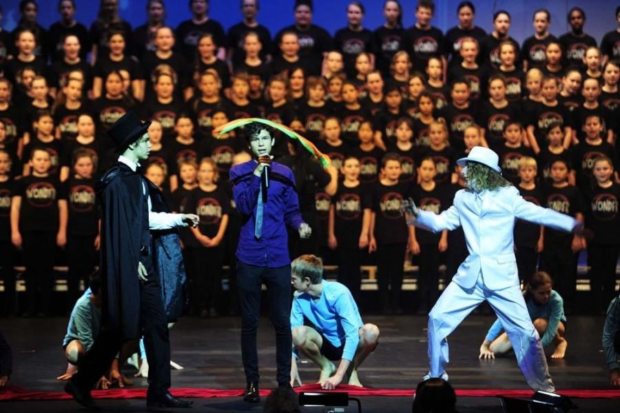 A group of people are performing on a stage in front of a large choir.