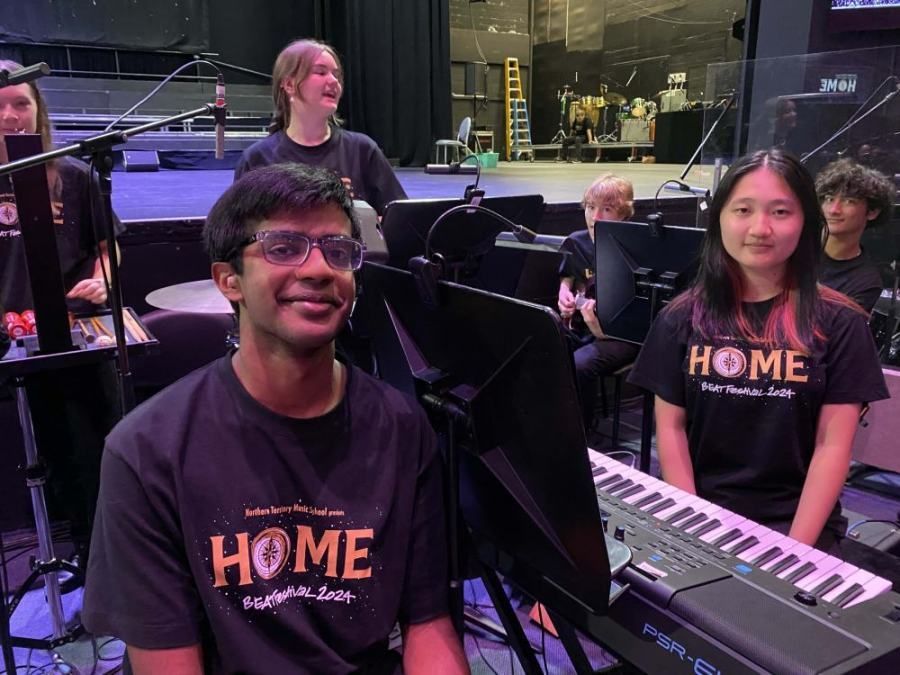 A man and a woman are sitting in front of a keyboard in a band.