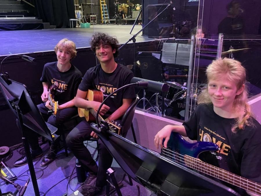 A group of young people are playing guitars on a stage.