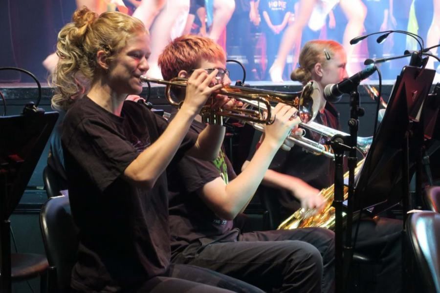 A woman is playing a trumpet in an orchestra