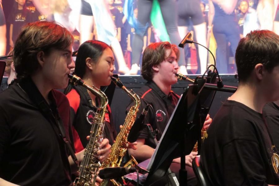 A group of people playing saxophones in a band