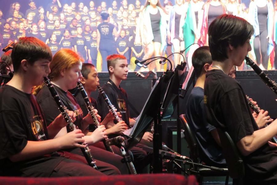 A group of children are playing clarinets in an orchestra