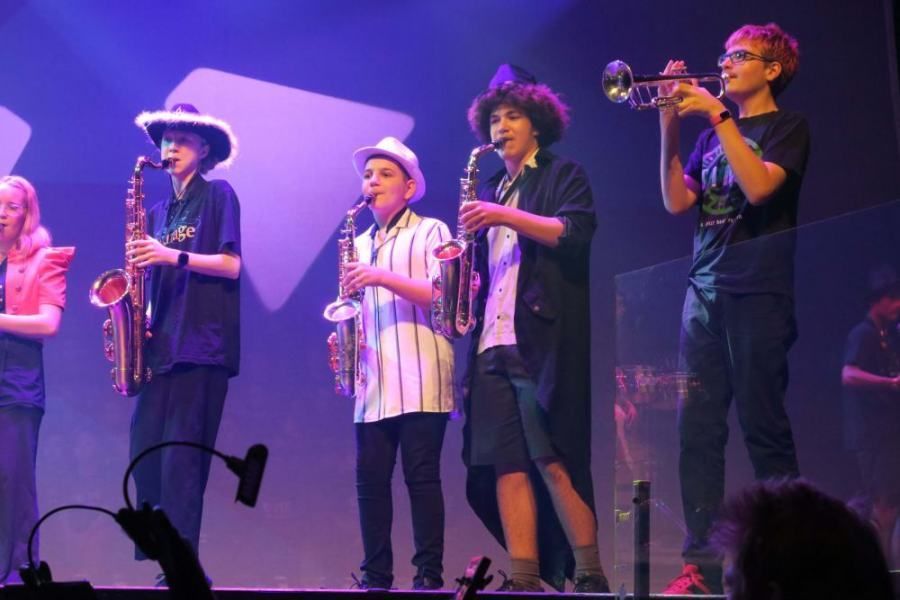 A group of young people playing instruments on a stage
