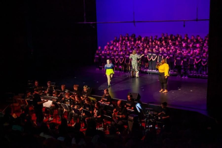A group of people are standing on a stage in front of a large audience.