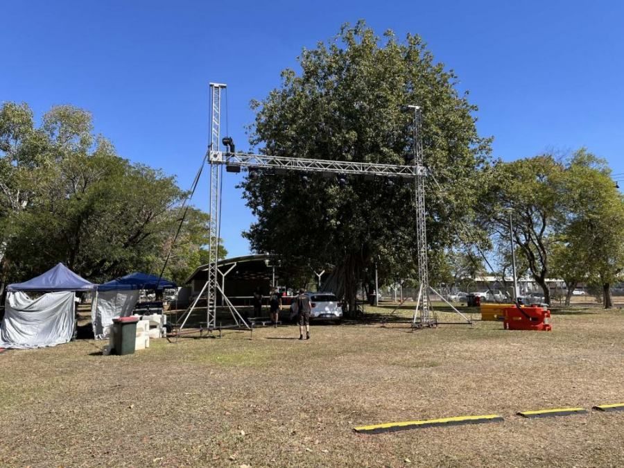 A large metal structure is sitting in the middle of a grassy field in a park.