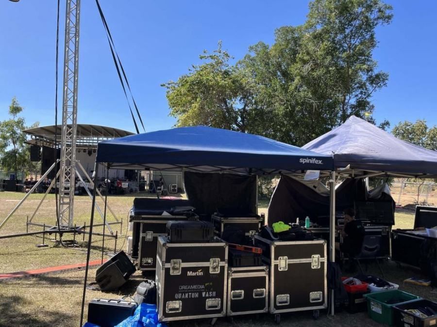 A blue tent is sitting in the middle of a field.
