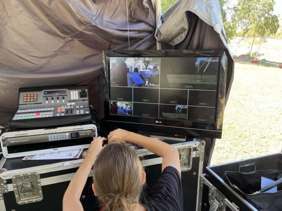 A woman is sitting in front of a television in a case.