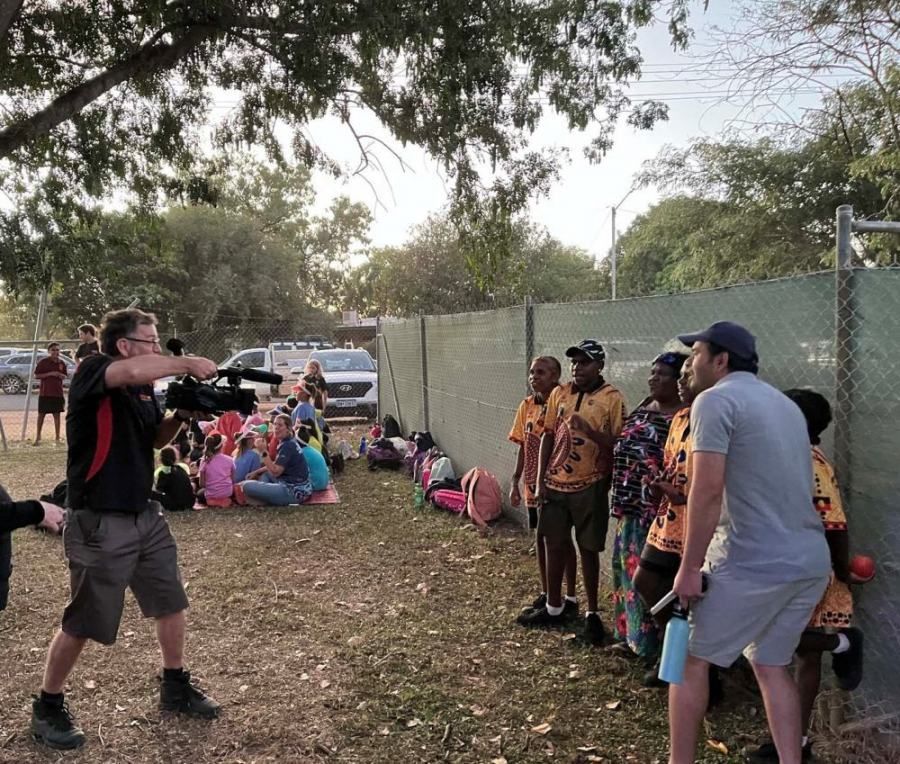 A man is holding a camera in front of a group of people