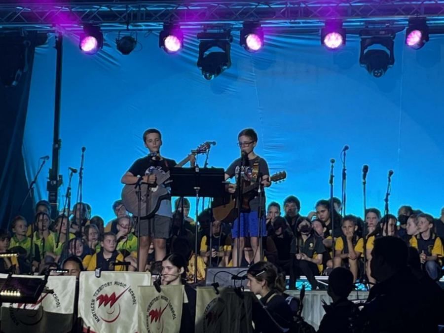A group of kids are playing instruments on a stage