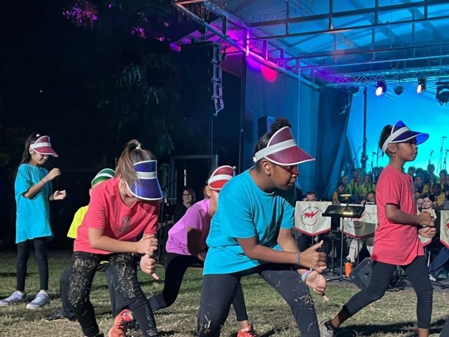 A group of young girls are dancing on a stage in front of a crowd.