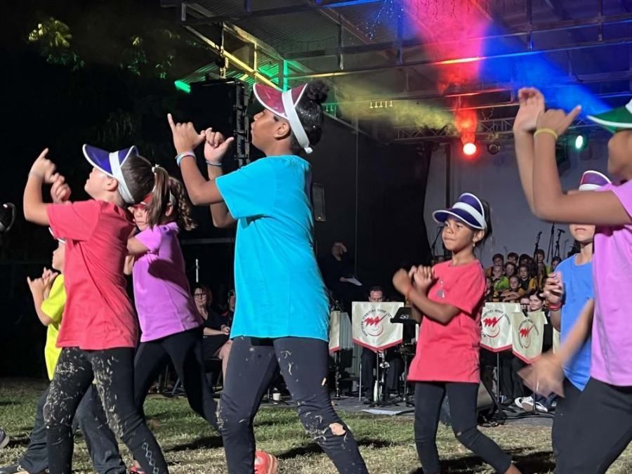 A group of children are dancing on a stage.