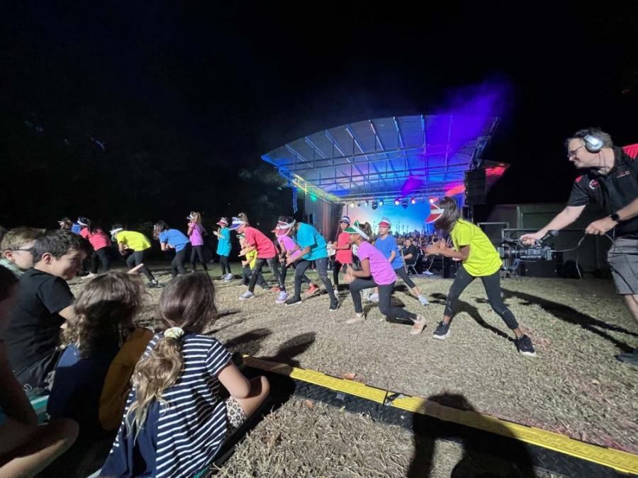 A group of people are dancing on a stage at night.