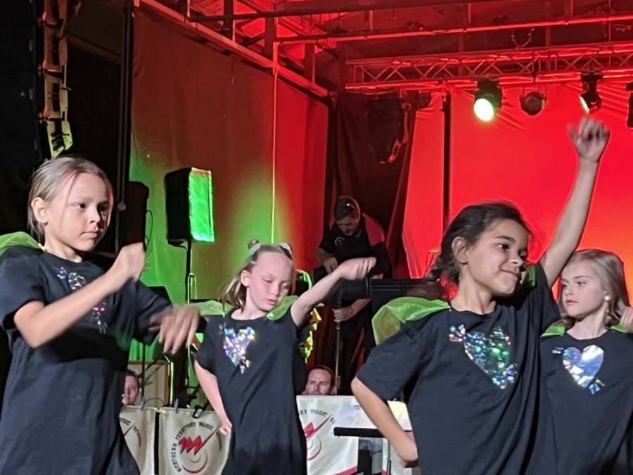 A group of young girls are dancing on a stage