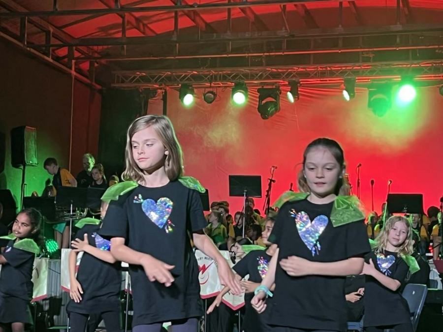 A group of young girls are dancing on a stage.
